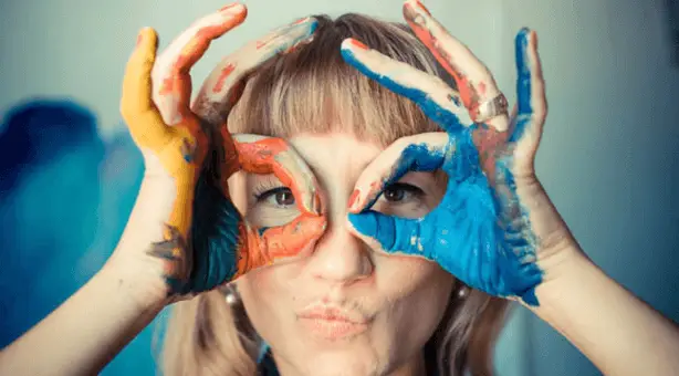 La clé de Fa, photo d'une femme avec de la peinture sur les mains, imitant un aviateur